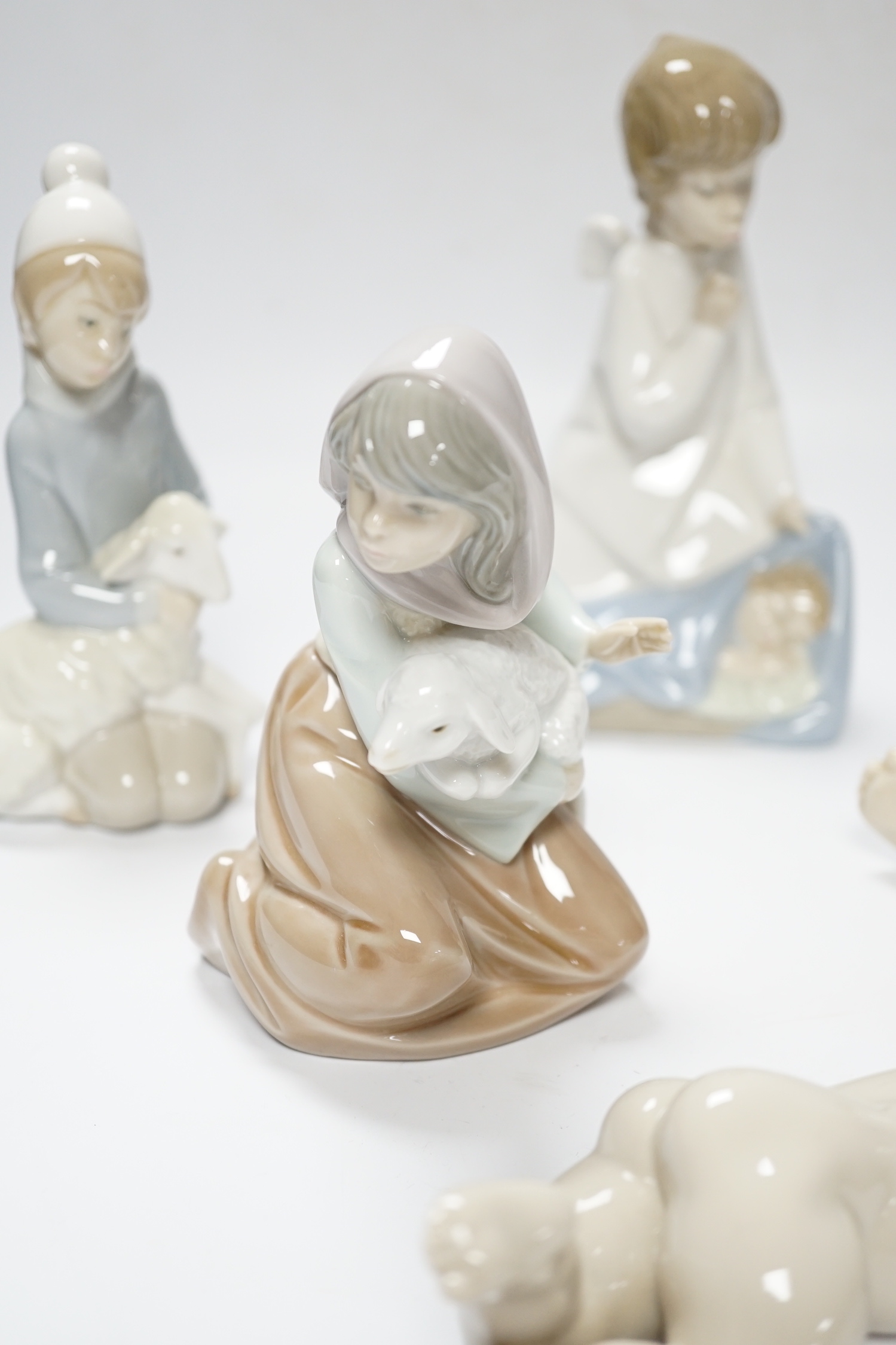 Five Lladro figures; two angelic, two nativity, one of a sleeping child and another of a girl with a lamb, all in boxed, largest 17cm high